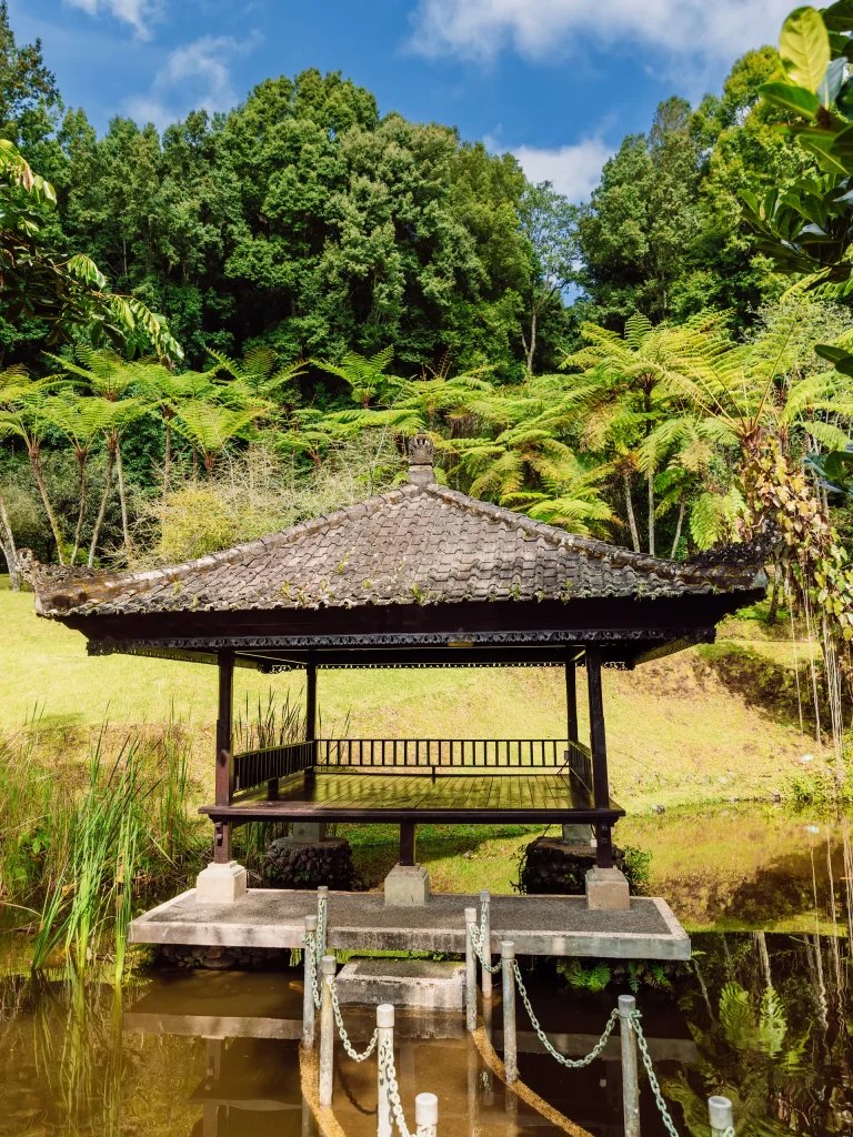 Kuta bali building on lake in botanic park with trees and fe