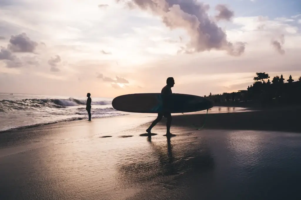 Kuta bali silhouetted surfers on a beach at sunset