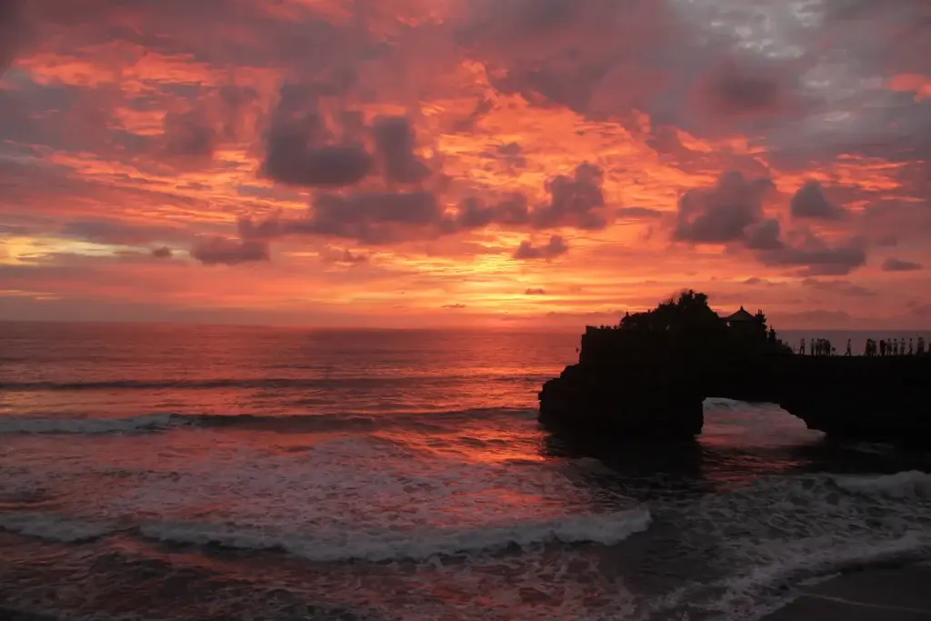 Sanur bali beach ocean sunset with distant silhouetted figures on